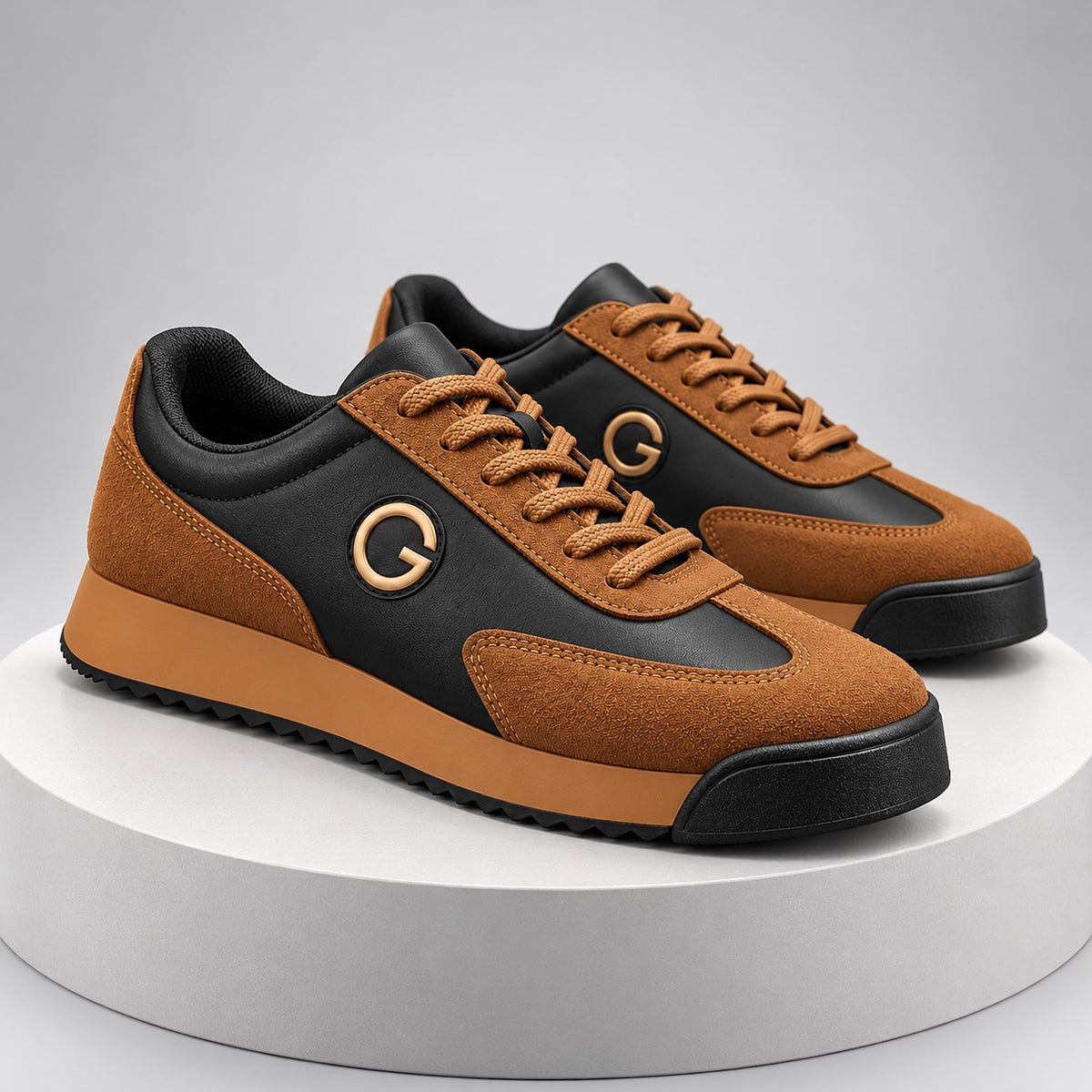 Low-top sneaker with a tan and black upper, tan sole, and gold ring logo detail.