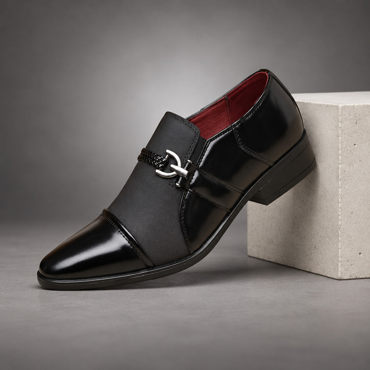 Black loafers with glossy leather-look sides and a matte suede-look across the upper. (plinth)